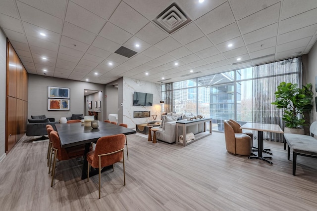 dining area featuring a wall of windows, recessed lighting, visible vents, and light wood-style flooring