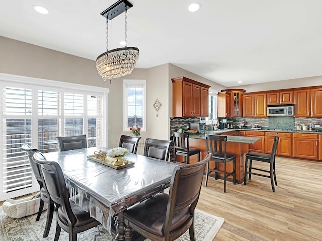 dining area with recessed lighting, a notable chandelier, plenty of natural light, and light wood finished floors