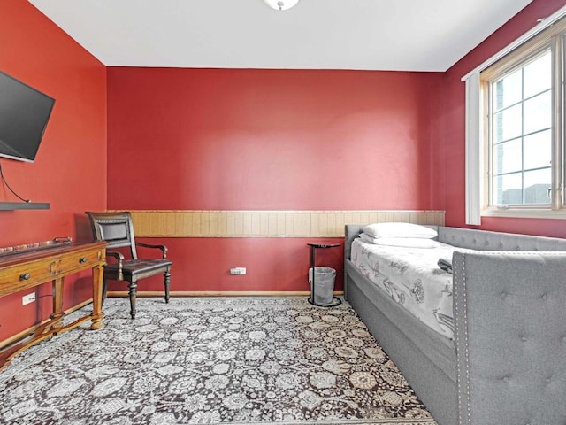 carpeted bedroom featuring wainscoting