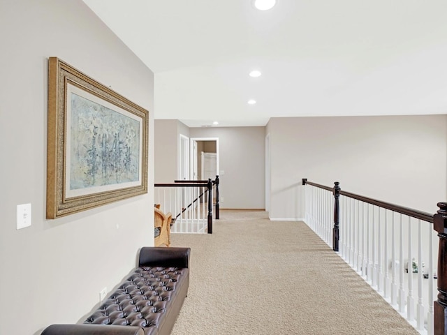 hallway featuring baseboards, carpet, an upstairs landing, and recessed lighting