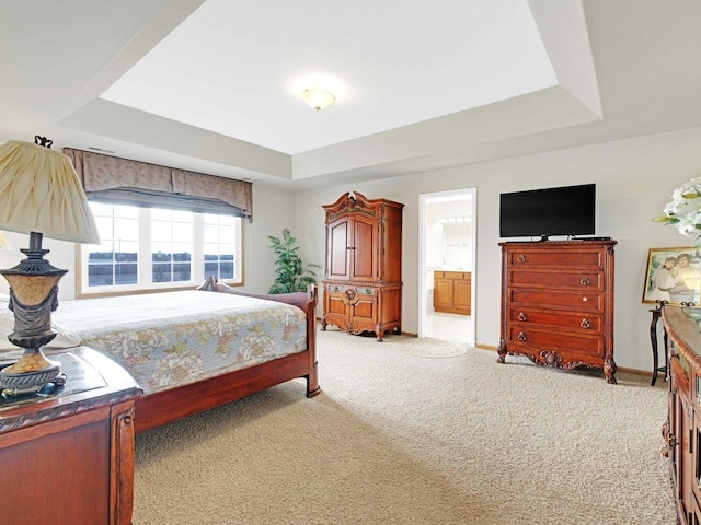 bedroom featuring light carpet, a raised ceiling, and baseboards