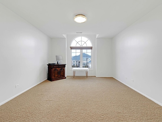 spare room with light carpet, visible vents, and baseboards