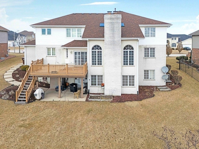 back of house with a patio, a chimney, a lawn, stairway, and a wooden deck