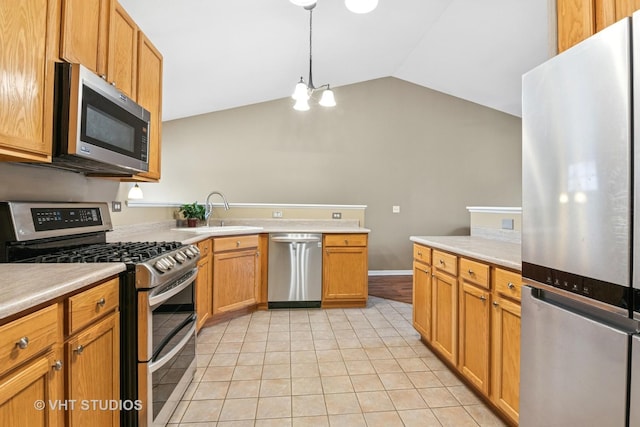 kitchen featuring light tile patterned floors, a sink, vaulted ceiling, light countertops, and appliances with stainless steel finishes