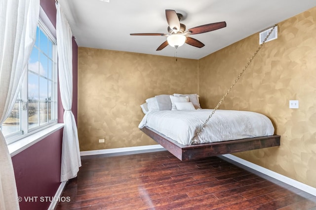 bedroom featuring wallpapered walls, baseboards, visible vents, and wood finished floors