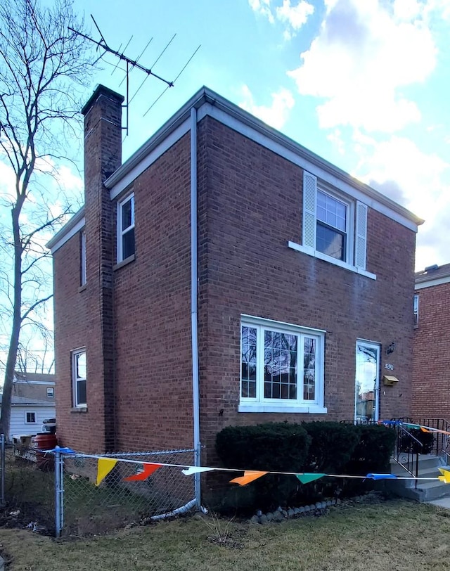 view of side of property featuring brick siding and a chimney