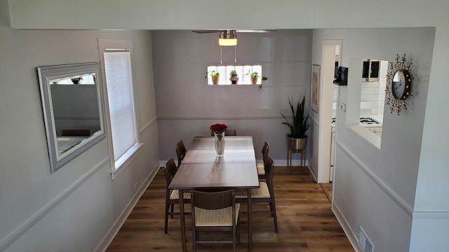 dining room with baseboards, wood finished floors, visible vents, and a healthy amount of sunlight