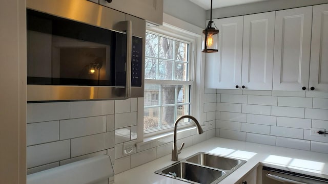 kitchen featuring appliances with stainless steel finishes, plenty of natural light, a sink, and backsplash