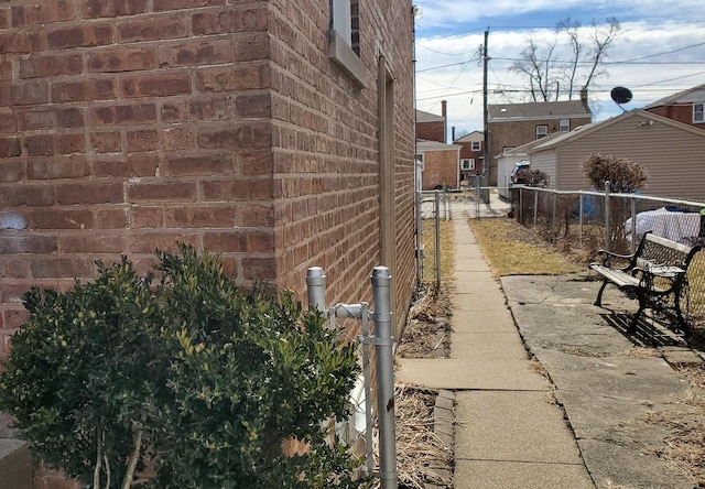 view of home's exterior featuring brick siding and fence