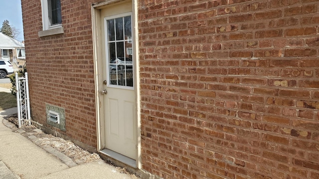 doorway to property with brick siding