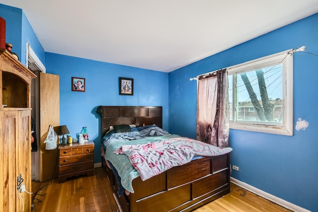 bedroom with baseboards and wood finished floors