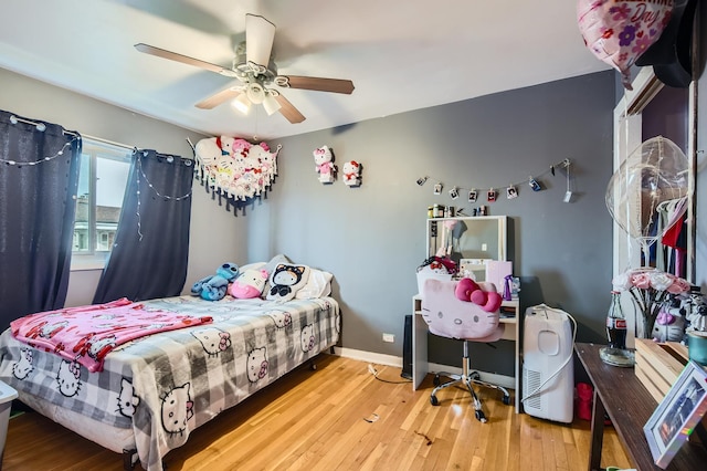 bedroom featuring a ceiling fan, baseboards, and wood finished floors