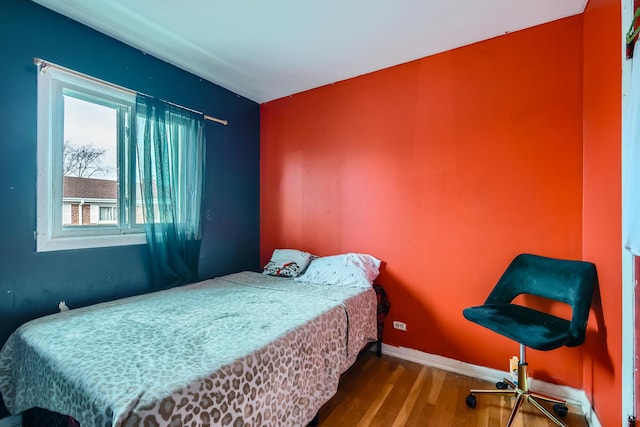 bedroom with wood finished floors and baseboards