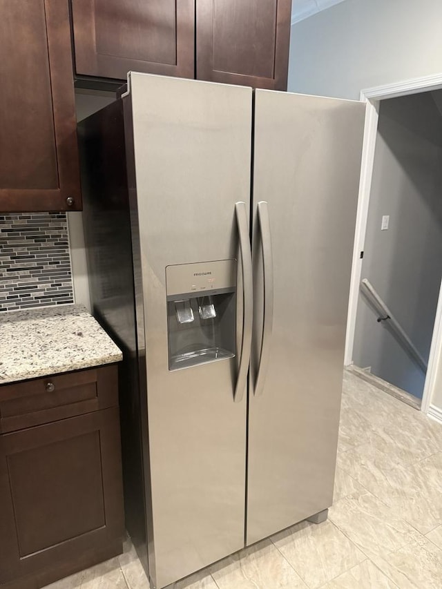 7929 S Manistee Ave, Chicago, IL 60617 - kitchen view of stainless steel fridge, dark brown cabinets, tasteful backsplash, and light stone counters