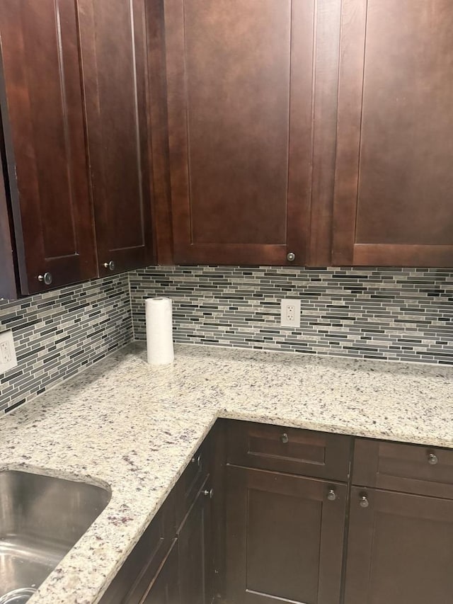7929 S Manistee Ave, Chicago, IL 60617 - kitchen featuring decorative backsplash, dark brown cabinets, and light stone counters