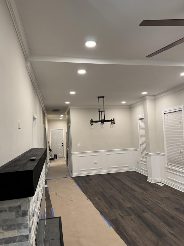 corridor featuring ornamental molding, recessed lighting, wainscoting, and dark wood finished floors