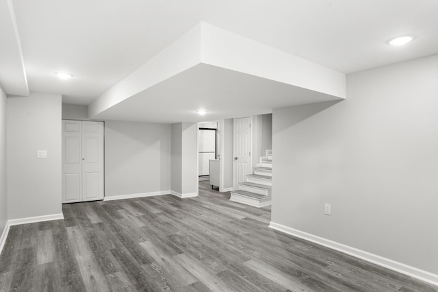 finished below grade area with stairway, wood finished floors, and baseboards