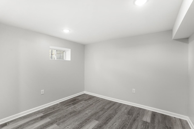 spare room with dark wood-style flooring and baseboards