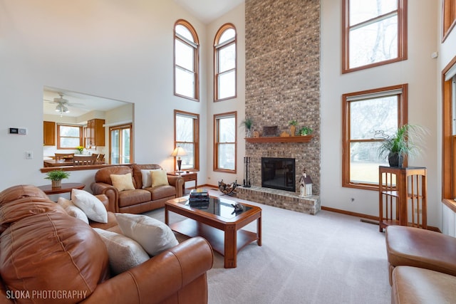 living room featuring light carpet, a brick fireplace, a high ceiling, and baseboards