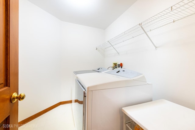 laundry area with laundry area, baseboards, and washing machine and clothes dryer