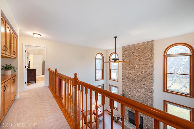 corridor with light carpet and an upstairs landing