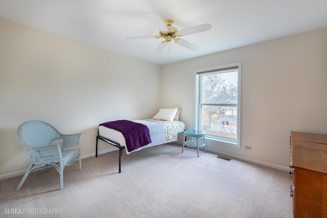 carpeted bedroom with a ceiling fan, visible vents, and baseboards