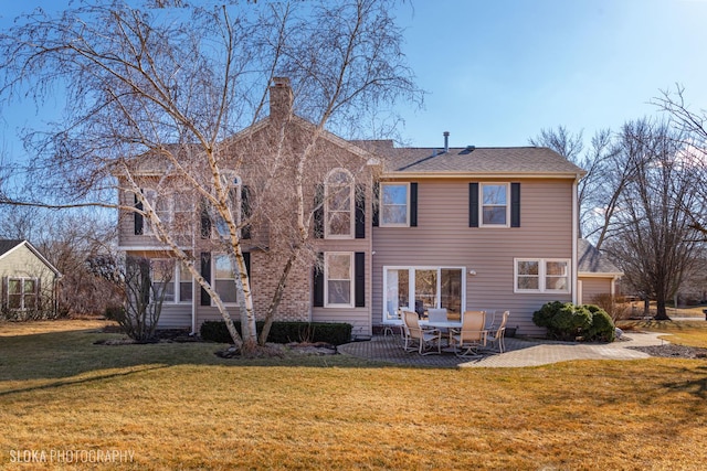 rear view of property featuring a sunroom, a patio area, a lawn, and a chimney