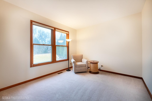 living area with carpet floors, visible vents, and baseboards