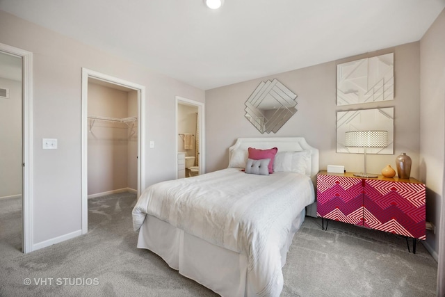 bedroom with a walk in closet, visible vents, a closet, carpet, and baseboards