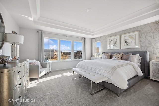 bedroom with baseboards, a raised ceiling, and carpet flooring