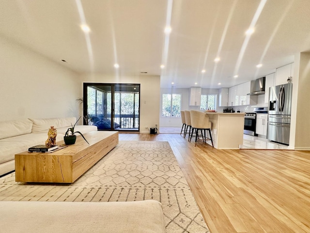 living room featuring baseboards, light wood finished floors, and recessed lighting