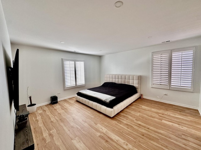 unfurnished bedroom with visible vents, baseboards, and wood finished floors