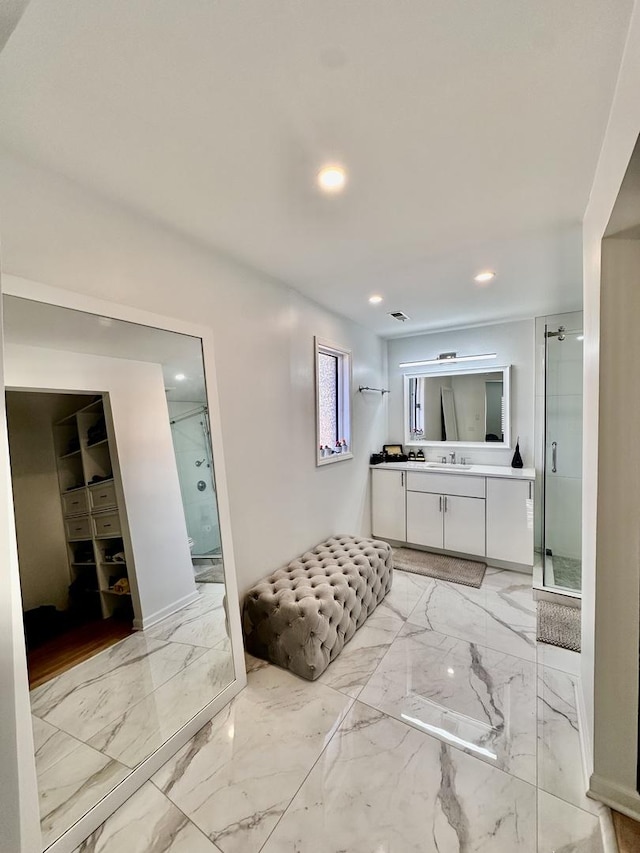 bathroom with marble finish floor, a shower stall, vanity, and recessed lighting