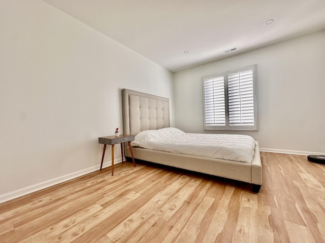 bedroom featuring visible vents, light wood-style flooring, and baseboards