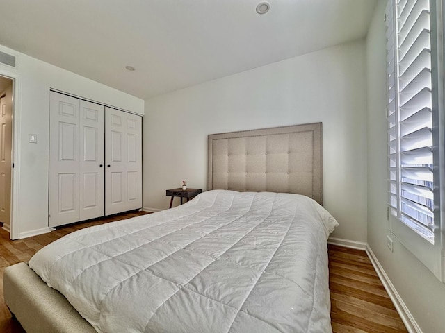 bedroom featuring a closet, wood finished floors, and baseboards