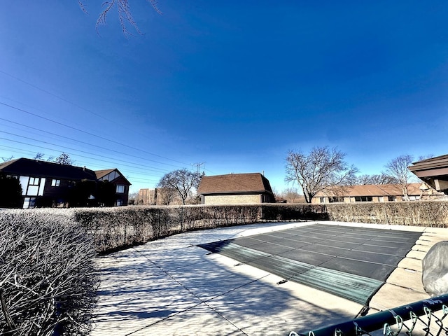 view of swimming pool featuring a patio and fence