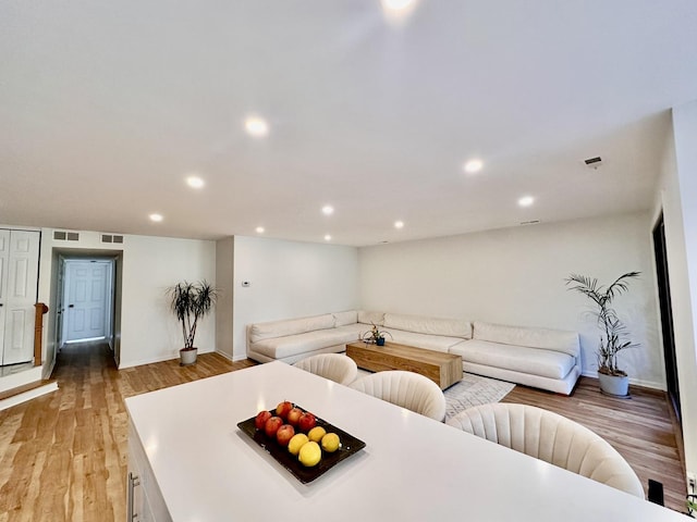 living area featuring light wood-style flooring, visible vents, baseboards, and recessed lighting