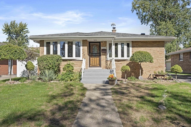 view of front facade with roof with shingles, a front lawn, and brick siding