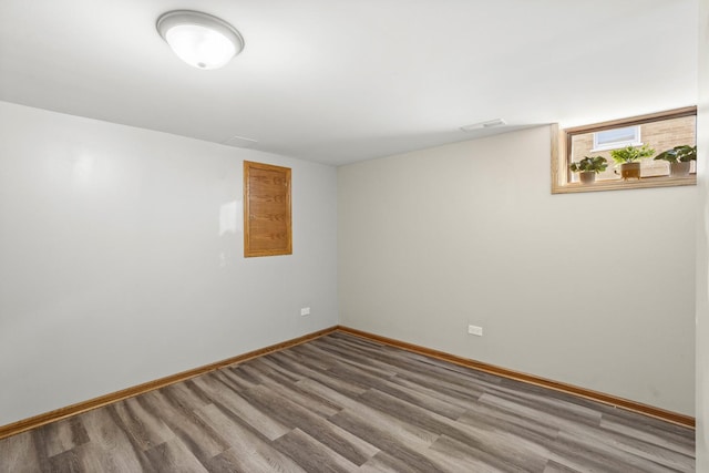 unfurnished room featuring baseboards and wood finished floors