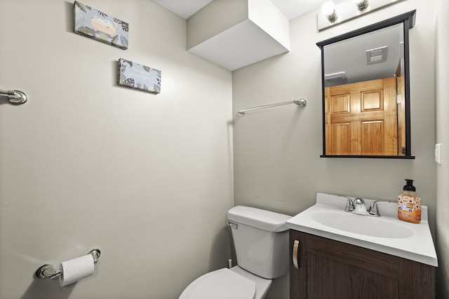 half bathroom with vanity and toilet