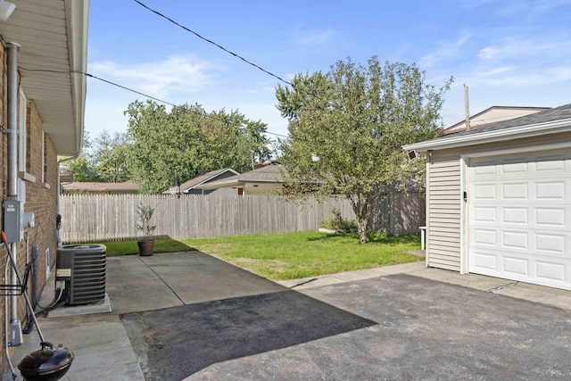 exterior space featuring a garage, fence, and central AC