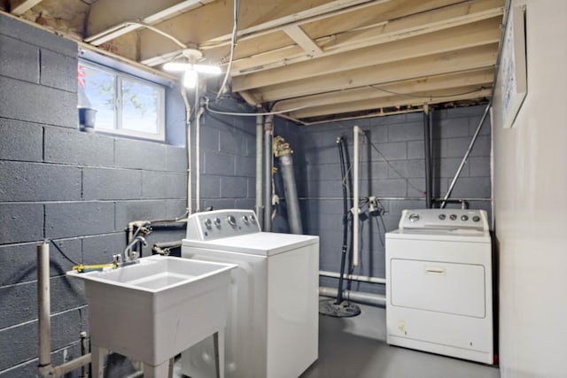 laundry area with laundry area, a sink, and washer and clothes dryer