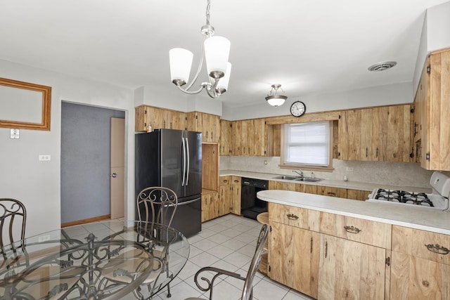 kitchen with a sink, light countertops, dishwasher, and freestanding refrigerator