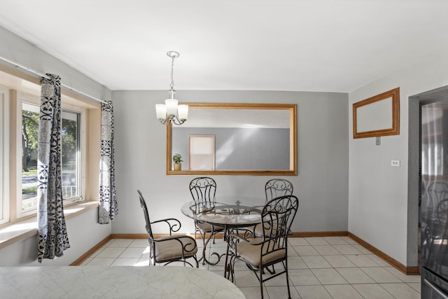 dining space with a chandelier, baseboards, and light tile patterned floors