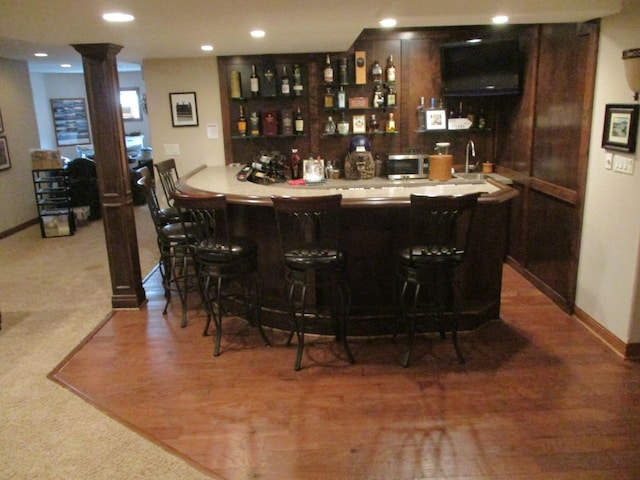 8032 Abbey Rd, Tinley Park, IL 60477 - indoor wet bar with decorative columns, stainless steel microwave, baseboards, carpet floors, and recessed lighting