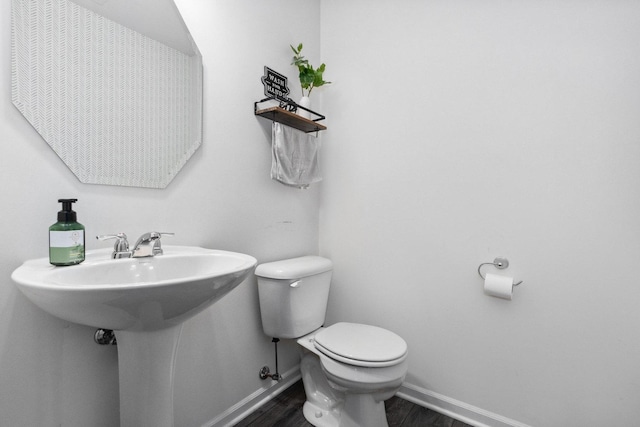 bathroom featuring baseboards, toilet, and wood finished floors