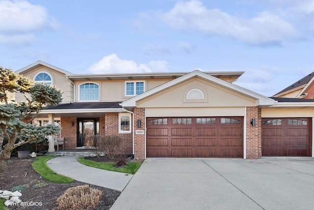 view of front of house with concrete driveway, brick siding, an attached garage, and stucco siding