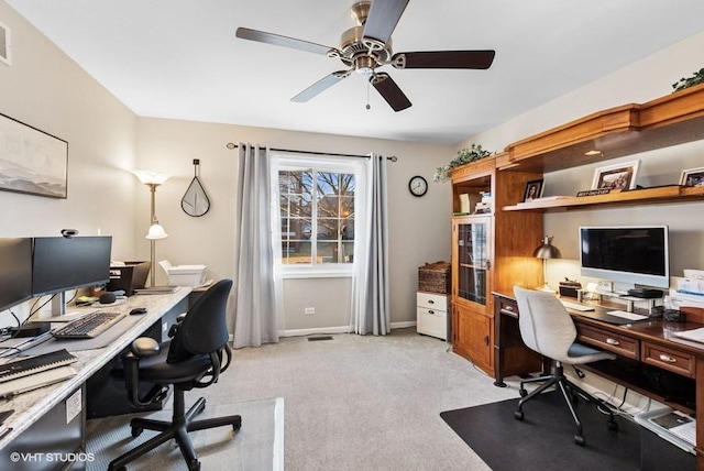 office featuring light carpet, ceiling fan, and baseboards