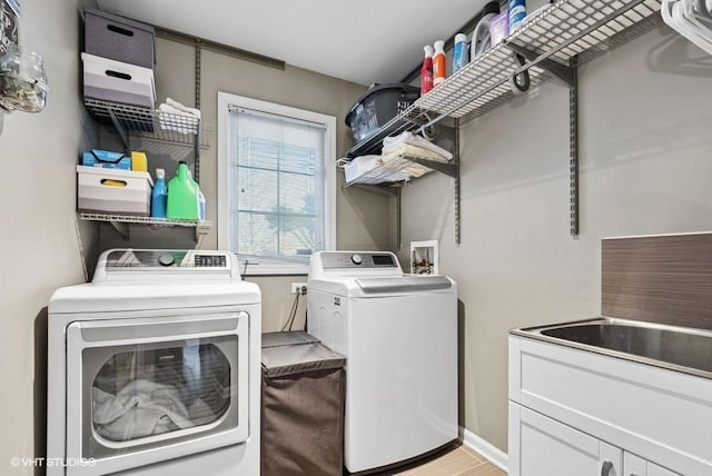 washroom with separate washer and dryer and cabinet space