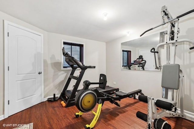 exercise room with baseboards and wood finished floors